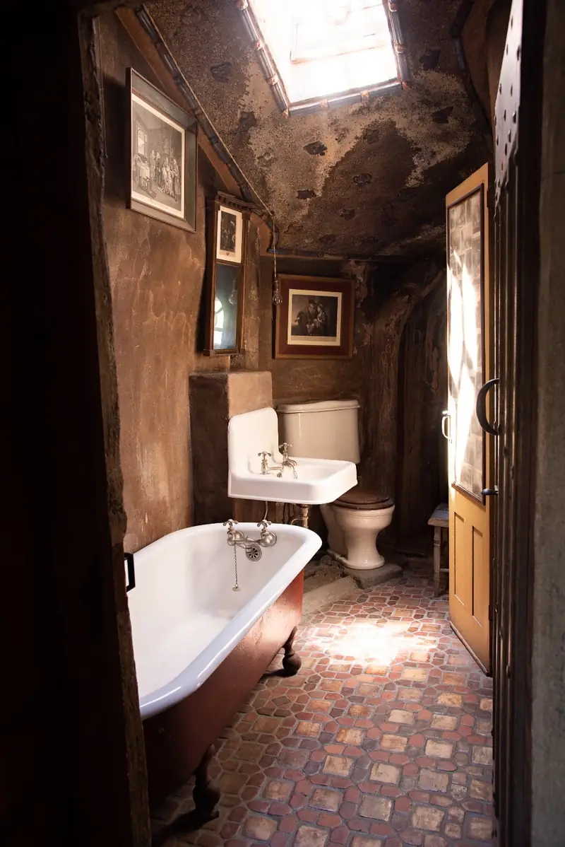 Salle de bain ancienne, baignoire sur pieds et sol carrelé
